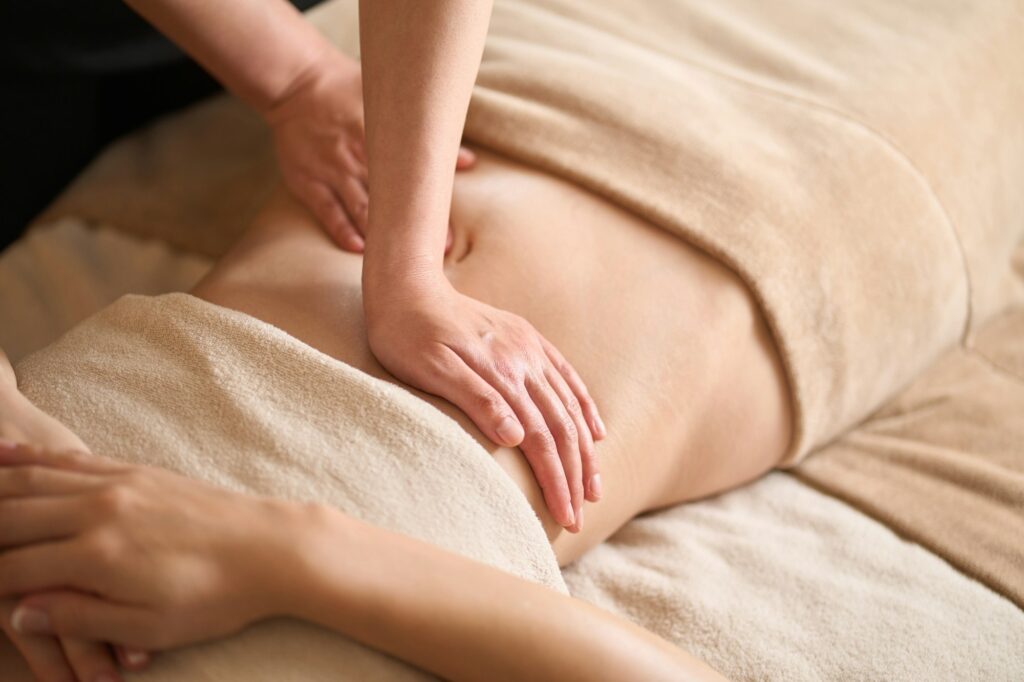 A woman receiving a belly massage at a beauty salon