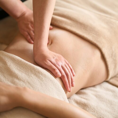 A woman receiving a belly massage at a beauty salon